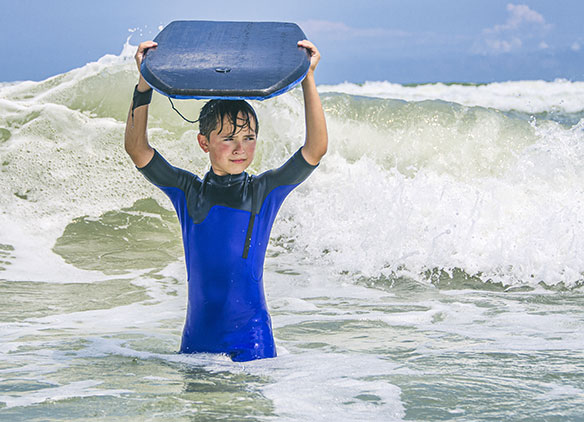 Picture of primary school student having a surfing lesson on a Dorset trip